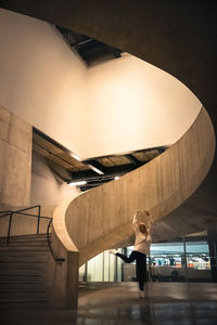 Rear view of woman standing on staircase