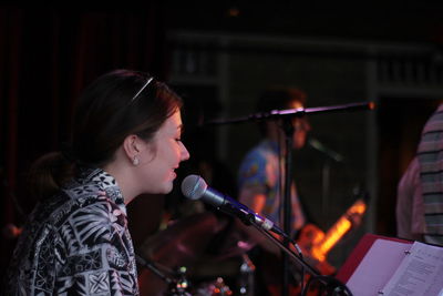 Side view of woman singing in music concert