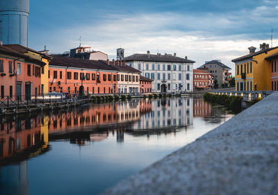 Reflection of buildings on river against sky