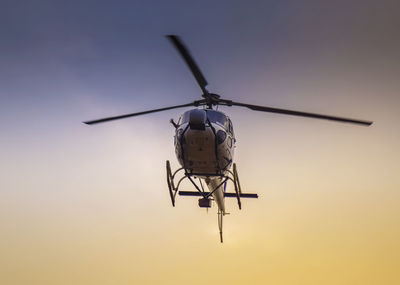 Low angle view of airplane flying against sky during sunset