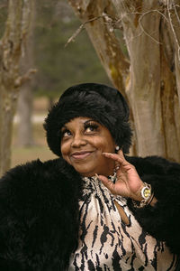Smiling woman wearing fur coat and knit hat