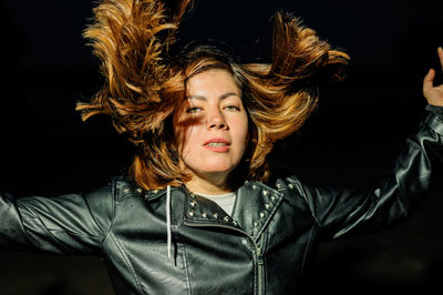 Portrait of smiling young woman with arms raised