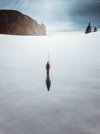 High angle view of woman standing on snow against sky