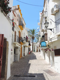 Narrow street amidst buildings in city against clear sky