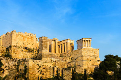 Low angle view of old ruins against blue sky