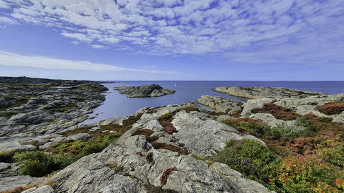 Rocks by sea against sky