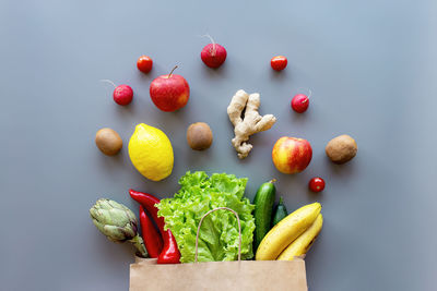 Healthy and organic food flay lay concept on gray background. eco bag with fruits and vegetables