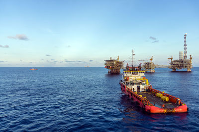 An anchor handling tugboat maneuvering near an offshore oil production platform at oil field