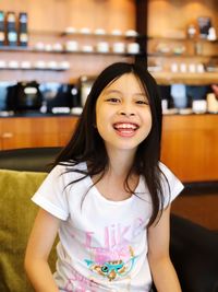 Portrait of smiling girl standing against wall