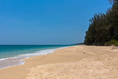 Scenic view of beach against clear blue sky