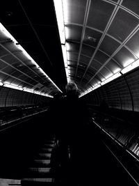 Rear view of woman standing on railroad station