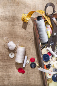 Directly above view of various sewing items on jute