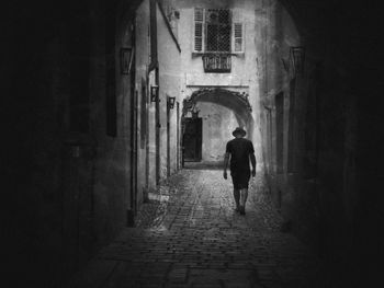 Full length rear view of people walking in alley