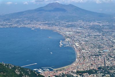 High angle view of city by sea against sky