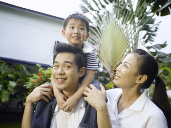 Parents enjoying with son on field at yard