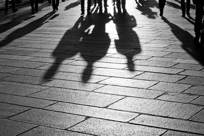 Shadow of people walking on footpath