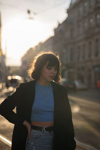 Portrait of young woman standing in city