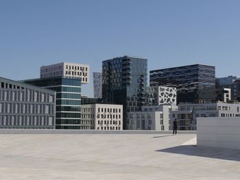 Diversity of buildings in city against clear blue sky