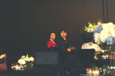 Couple sitting on chairs during wedding ceremony
