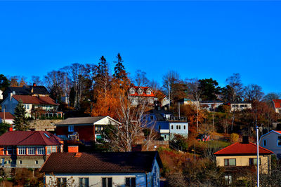 Houses in town against clear blue sky