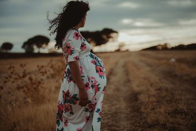 Side view of pregnant woman standing on land