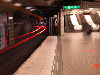 Train at railroad station platform at night