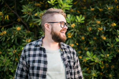 Happy man in front of plant