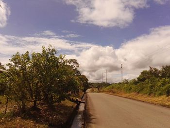 Road amidst trees against sky