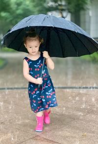 Portrait of young  girl with umbrella walking in the rain 
