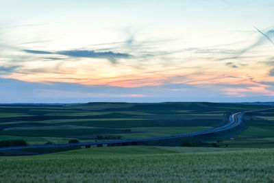 Scenic view of agricultural field against sky during sunset