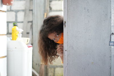 Portrait of cute girl looking through pole