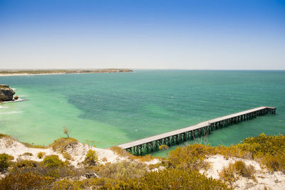 Long wooden jetty stretches out into clear water at stenhouse bay, south australia