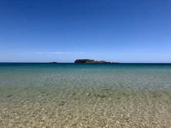 Scenic view of sea against clear blue sky