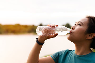 Fitness asia woman drinking water after running