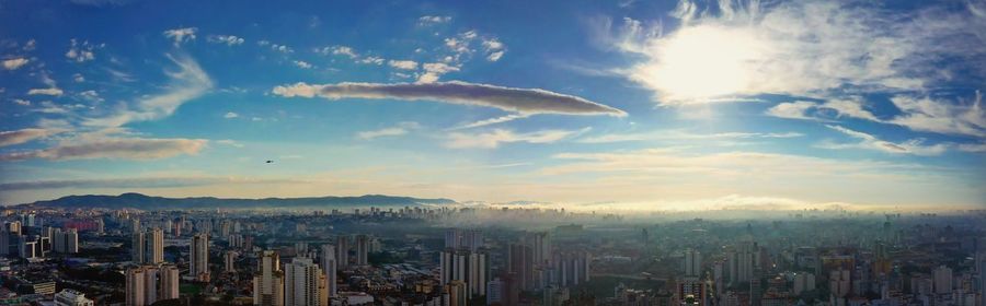 Aerial view of buildings in city against sky