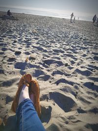 Low section of woman relaxing on beach