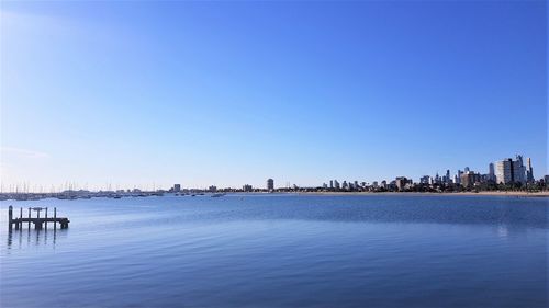 Scenic view of sea and buildings against clear sky