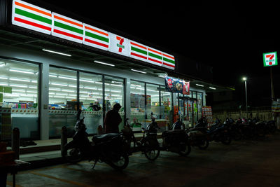 People sitting on illuminated street at night