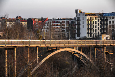 Bridge over river amidst buildings against sky
