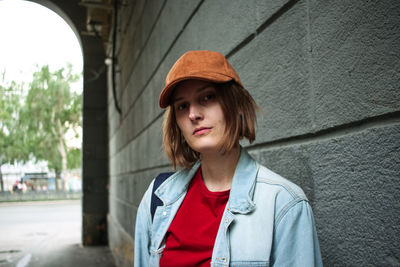 Portrait of beautiful woman standing against wall outdoors