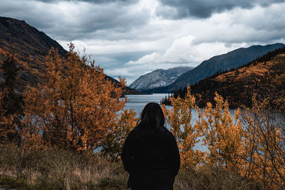 Rear view of person standing on mountain during autumn