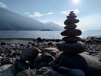 Stack of stones on beach against sky