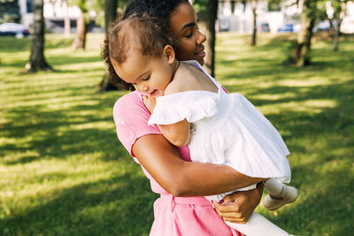 Smiling woman with girl at park