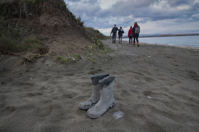 Rubber boots on sand at beach