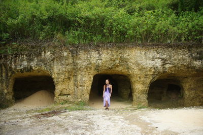 Woman standing against caves at beach