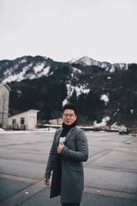 Portrait of young man standing in snow