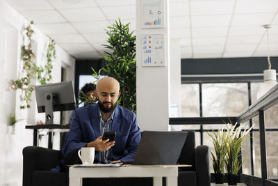 Side view of young man using mobile phone