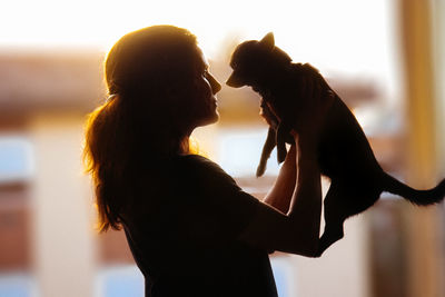 Side view of woman with dog at home