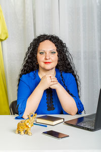 Portrait of young woman sitting on table