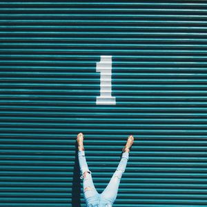 Low section of woman on turquoise corrugated iron